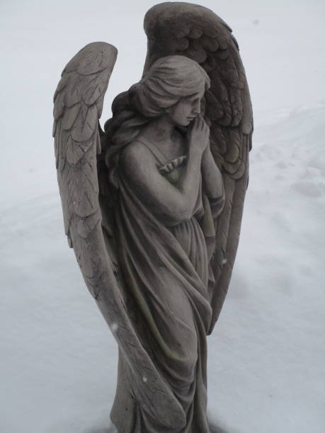 resin reproduction statue of angel in the snow, facing three-quarters front