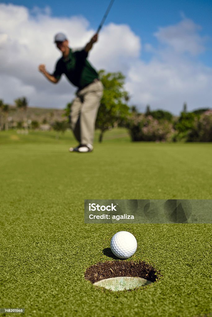 Golf ball enfoques orificio como golfista celebra en el fondo - Foto de stock de Golf libre de derechos