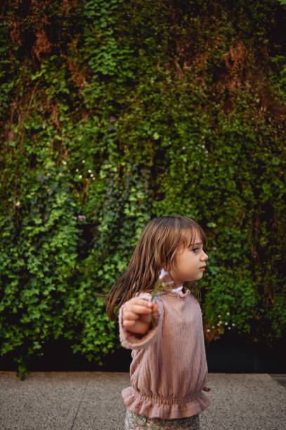 istock little girl holding a flower. 1482016234