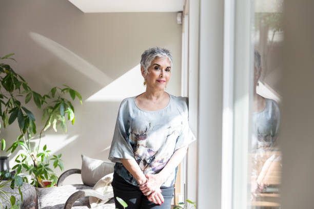 istock Senior woman clasps hands and looks at camera 1482018327