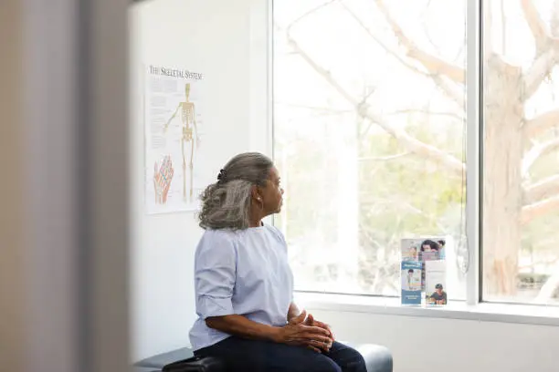 Photo of Senior adult woman stares out the window in doctor's office