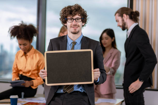 istock Handsome businessman  holding black board  in bright modern office 1482027690