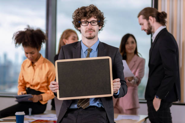istock Handsome businessman  holding black board  in bright modern office 1482027694