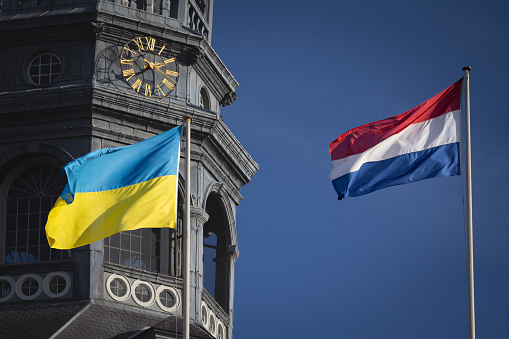 Picture of the dutch and ukrainian flags waiving together in maastricht, celebrating the solidarity between the netherlands and Ukraine in the war against russia.
