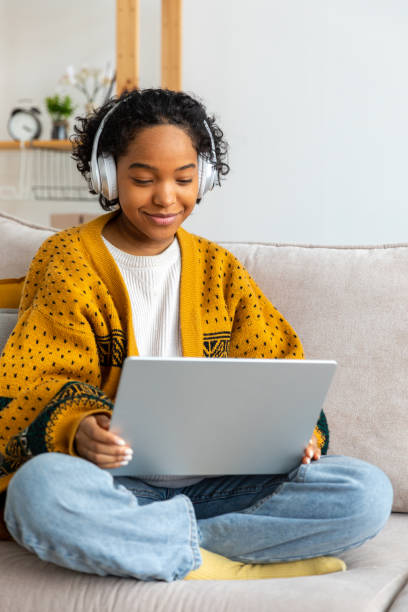 istock African american girl using laptop at home office looking at screen typing chatting reading writing email. Young woman having virtual meeting online chat video call conference Work learning from home 1482050140