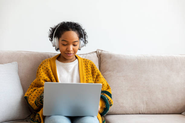 istock African american girl using laptop at home office looking at screen typing chatting reading writing email. Young woman having virtual meeting online chat video call conference Work learning from home 1482050148