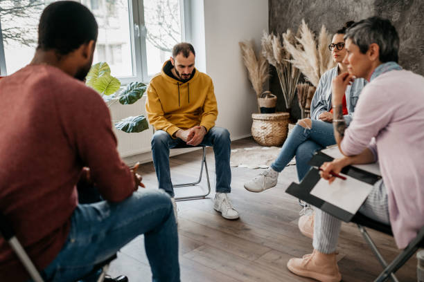 Multiracial group of people having a psychotherapy stock photo