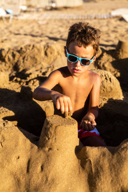istock Boy building a sand castle on the beach 1482054645