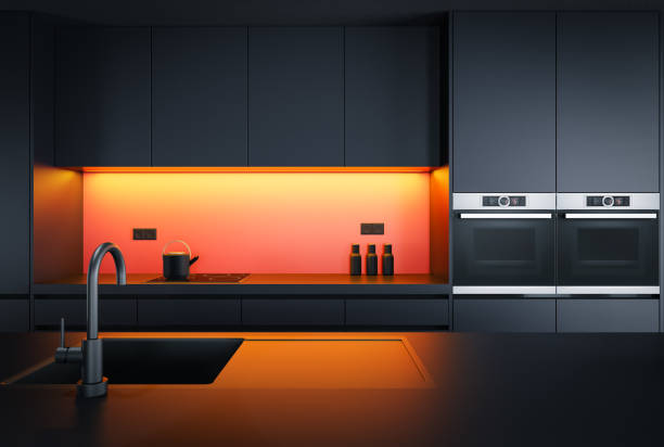 Black Modern minimalist kitchen with long island with stools. Dark materials. stock photo