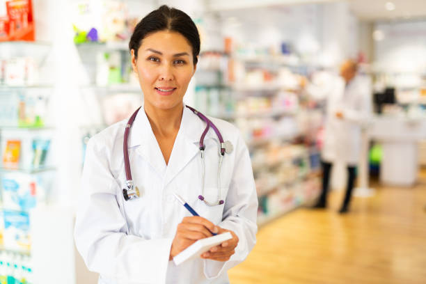 istock Female pharmacist standing and writing recipe 1482057387