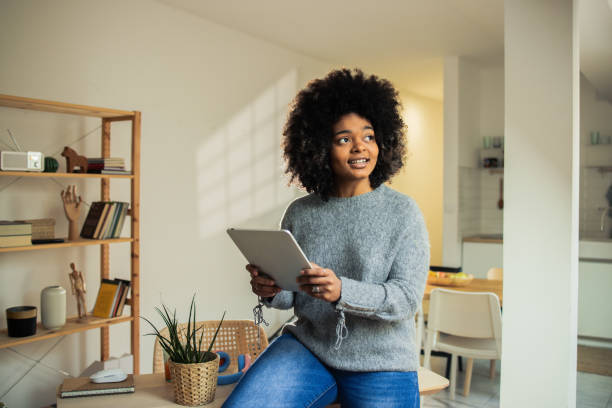 istock Happy woman is browsing the internet on her digital tablet 1482059701