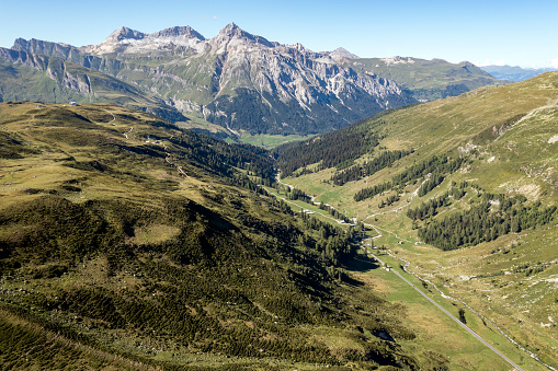 An aerial view of mountain landscape with a winding road, Splügen Pass, Graubunden Canton, Swiss Alps.