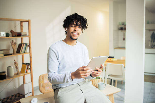 istock Happy man is browsing the internet on his digital tablet 1482059832