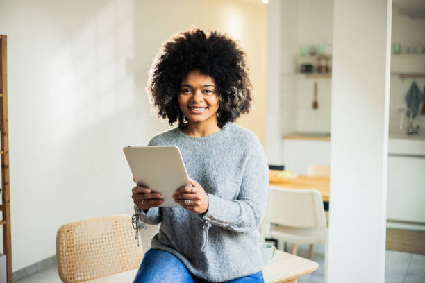 istock Happy woman is browsing the internet on her digital tablet 1482059833