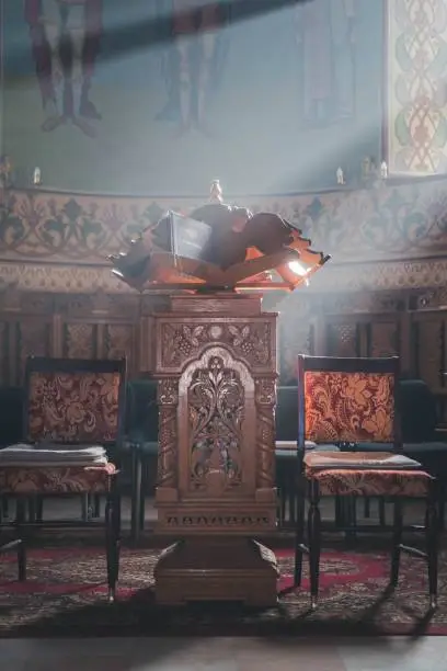 Photo of Interior of an old church in Romania with sunbeams from the windows