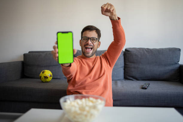 istock Handsome young man watching soccer match on TV at home 1482071520