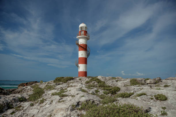 istock Lighthouse on a rocky shore in Cancun. Clear sky and blue sea. Mexico. 1482080031