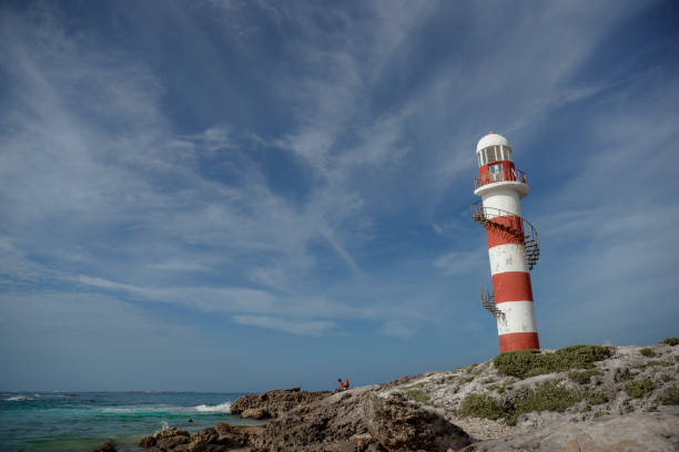 istock Lighthouse on a rocky shore in Cancun. Clear sky and blue sea. Mexico. 1482080091