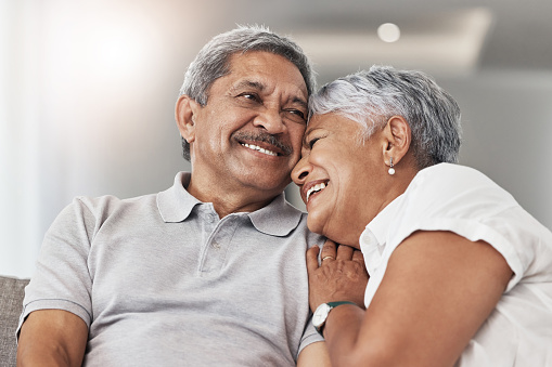 Love, relax and senior couple laugh at funny joke, enjoy quality time together and bond on home living room sofa. Retirement, smile and elderly man, woman or people happy in Rio de Janeiro Brazil