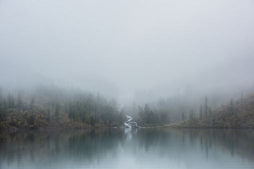 Morning fog on the lake, golden sunrise over the water.