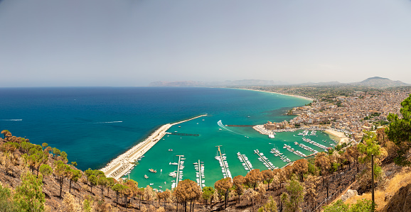 Panorama of Western Sicily - view of the Mediterranean Sea and Castellammare del Golfo Bay with numerous white yachts. Clear cloudless sky in the background.
