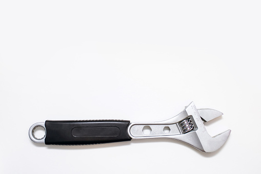 Modern adjustable wrench on a white background with free space for text. The concept of a tool for repair or construction. Special tool for repairing pipes and clamping nuts with diameter adjustment