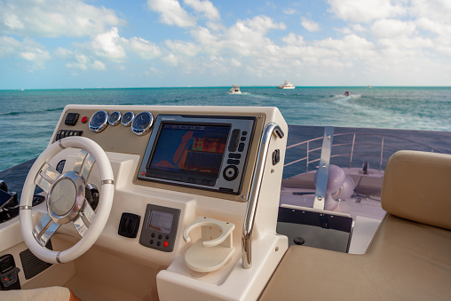 Steering wheel and control panel on luxury motorboat, background with copy space, full frame horizontal composition