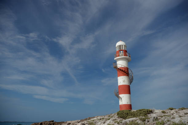 istock Lighthouse on a rocky shore in Cancun. Clear sky and blue sea. Mexico. 1482086359