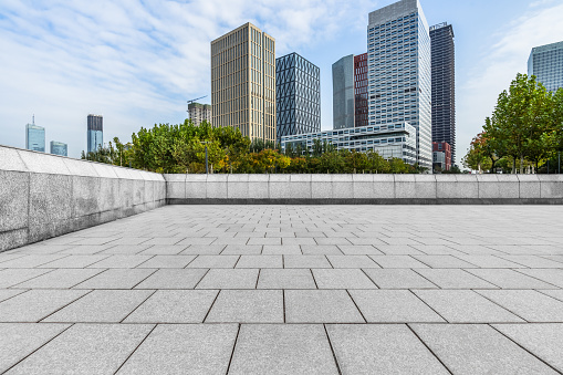 Clean square pavement and city skyline on a sunny day. Urban architectural landscape in China