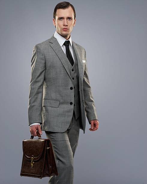 istock A businessman carrying a briefcase isolated on gray 148209440