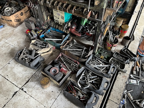 Yogyakarta, Indonesia - April 14, 2023: Top view many kinds of old, rusty and dirty steel hand tools, pliers screwdriver, and wrench at workshop