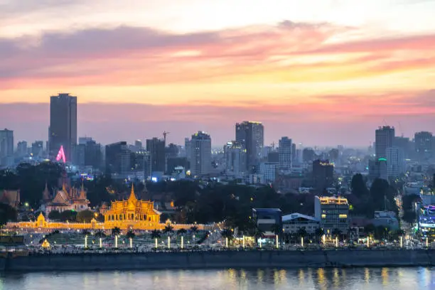 The golden afterglow over Cambodia's capital city,it's busy Riverside and famous landmarks and the Royal Palace,as the setting sun sinks from behind the Tonle Sap river.
