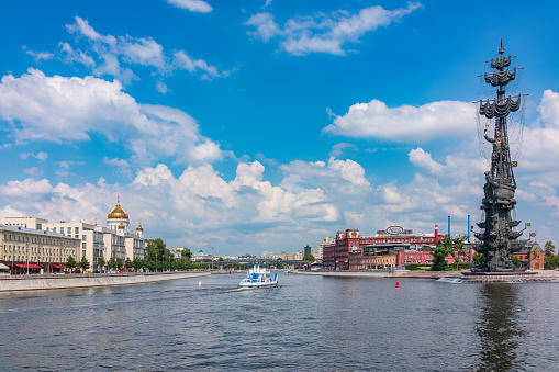 Moscow, Russia - July 25, 2022: Moscow river and Peter the Great Statue. Sculpture by Zurab Tsereteli. The Cathedral of Christ the Savior and the Confectionery factory Red October in background.