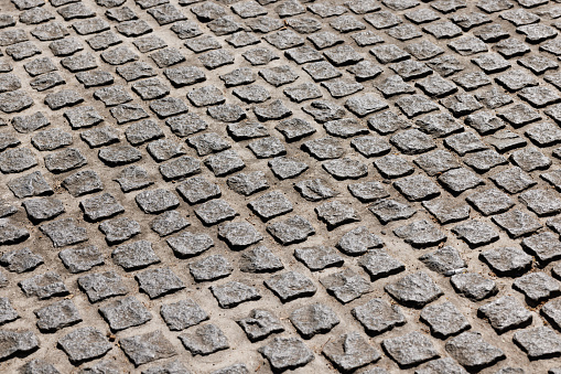 Road made with gray evenly cut stones.