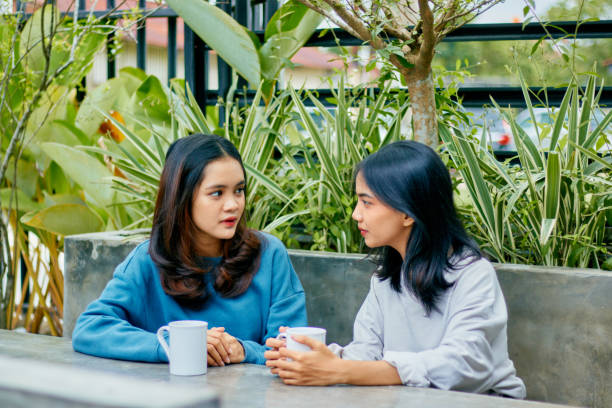istock Asian young woman focuses while talking with her friend. 1482121103