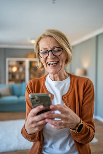 istock Mature woman using smart phone at home 1482124555