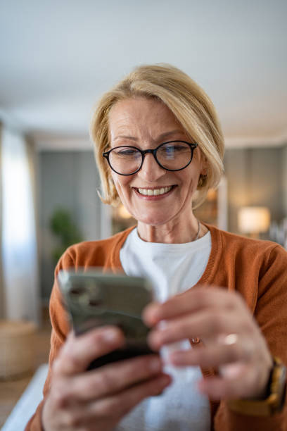 istock Mature woman using smart phone at home 1482124556