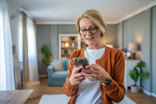 istock Mature woman using smart phone at home 1482124586