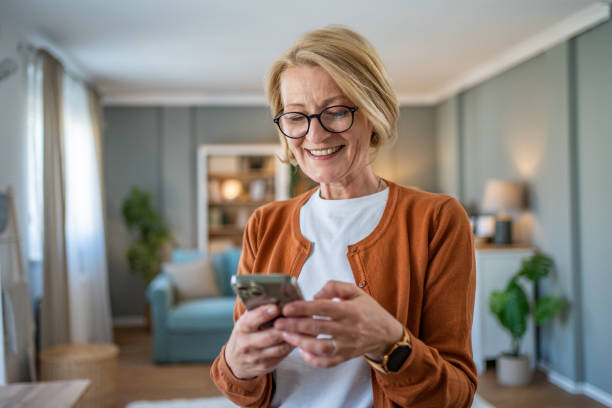 istock Mature woman using smart phone at home 1482124591