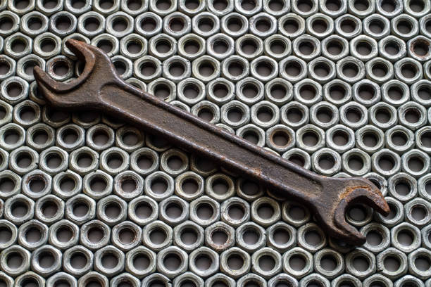 Rust wrench on the background of iron nuts. Old rusty wrench.