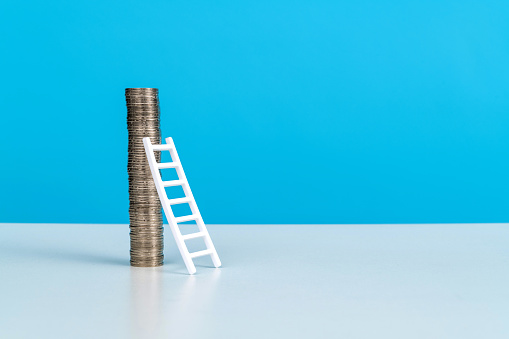 Ladder leaning to stack of coins