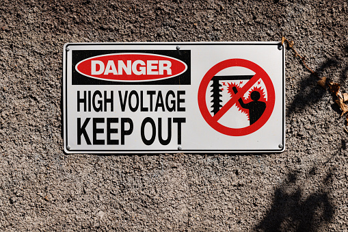 Danger, high voltage, keep out sign on an old wall.