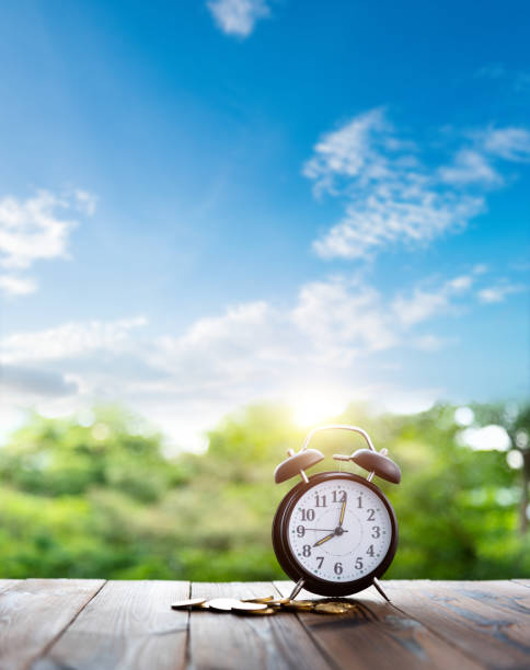 Alarm clock and coins on the table