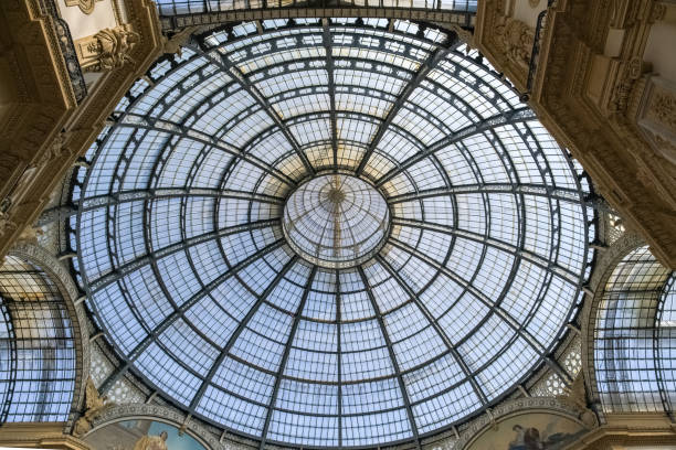 Glass dome of the world-renowned Galleria Vittorio Emanuele II in Milan, Italy, a true marvel of architectural splendor. With its soaring glass dome and ornate facades, this historic arcade beckons visitors into a realm of unparalleled luxury and elegance. As you step beneath its grand arches, you are enveloped in an atmosphere of opulence and sophistication, where the finest boutiques and cafes line the marble-floored corridors. The Galleria serves as more than just a shopping destination; it is a symbol of Milan's status as a global capital of fashion and design, a testament to the city's unwavering commitment to excellence. This gallery is one of the world's oldest shopping malls.