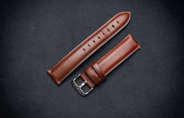 istock Luxury, minimalist brown tanned leather watch strap on a black surface background. 1482136910