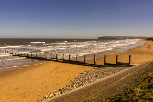 View form the promenade in Redcar looking at the beach towards Marske and Saltburn. The tide is nearly in and the sea has a lot of waves breaking onto the beach.