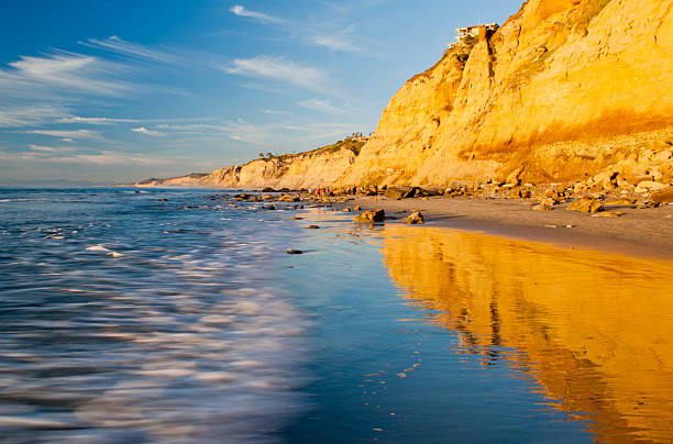 La Jolla Beach at Sunset Golden sunlight reflecting from the cliffs north of Scripps Pier in La Jolla, California, looking towards Blacks Beach and Torrey Pines State Natural Reserve. torrey pines state reserve stock pictures, royalty-free photos & images