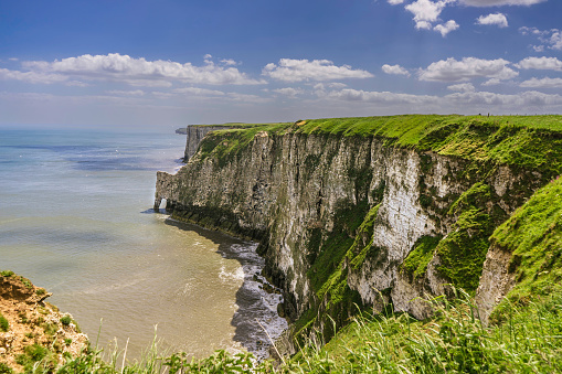This photo was taken in France, north of Normandy, in Etretat. You can see the city, the pebble beach and the dike. You can see the cliffs in the background.