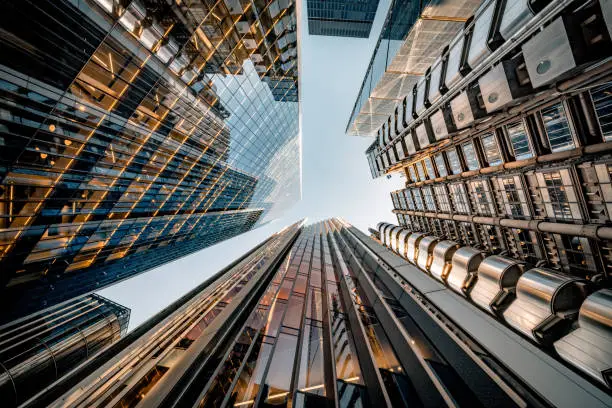 Highly detailed abstract wide angle view up towards the sky in the financial district of London City and its ultra modern contemporary buildings with unique architecture on a cloudy day. Including some iconic buildings at Lime street: Lloyd’s building, WTW (Willis Towers Watson, The Scalpel building, The Leadenhall building, The Aviva building, etc. Shot on Canon EOS R5 full frame with 10mm prime wide angle lens. Image is ideal for background with many concepts.