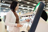 Information security can use technology to control and store systematically. Asia travel woman check in at automatic check in kiosk. Touching screen and choose flight detail and insert passport to record data in system to create boarding pass.